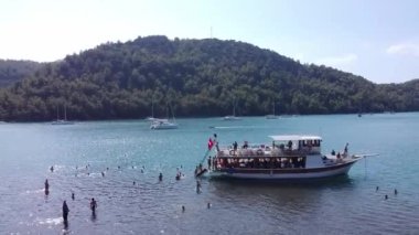 Marmaris 'teki Kizkumu Sahili' nin havadan görüntüsü. Ada koyunda kumsallı bir yat. Mavi denizde yüzen insanlar. Türkiye 'de turistik tekne gezisi. Türkiye - 9 Eylül 2021