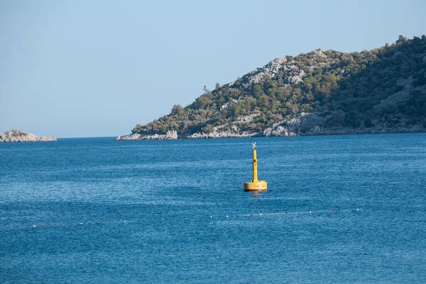 Yellow Sea Buoy in turquoise water of Mediterranean Sea. Marine Navigation Buoy. Safe water mark