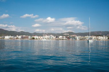 Landscape view of Marmaris city in Turkey. Seaside of resort town with white sand beach. City coastline. Marmaris, Turkey - September 8, 2022.