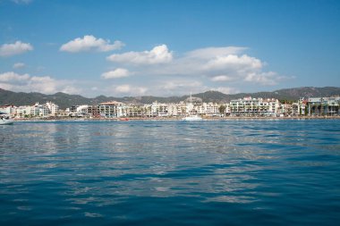 Landscape view of Marmaris city in Turkey. Seaside of resort town with white sand beach. City coastline. Marmaris, Turkey - September 8, 2022.
