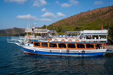 Pleasure yacht in the sea. Tourist ship with people on board with turkish flag sails on the waves. Fast moving excursion ship boat. Marmaris, Turkey - September 9, 202