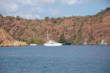 Big white modern yachts moored in Aegean sea near Turkey coast. Luxury white boat yacht against of the resort city. Ships in sea. Sea traveling. View from boat. Marmaris, Turkey - September 9, 2022.