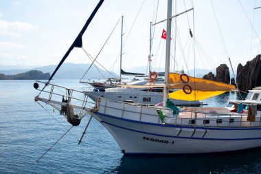 Türkiye kıyısı yakınlarındaki Ege Denizi 'nde demirlemiş beyaz yelkenli yatlar. Lüks beyaz tekne yatı. Denizdeki gemiler. Deniz yolculuğu. Tekneden görüntü. Marmaris, Türkiye - 9 Eylül 2022.