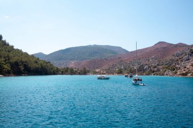Türkiye kıyısı yakınlarındaki Ege Denizi 'nde demirlemiş beyaz yelkenli yatlar. Lüks beyaz tekne yatı. Denizdeki gemiler. Deniz yolculuğu. Tekneden görüntü. Marmaris, Türkiye - 9 Eylül 2022.