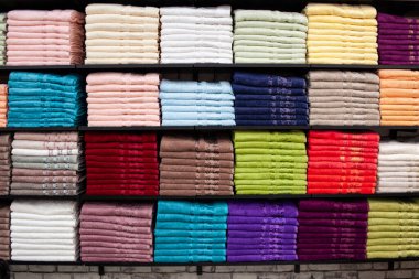 Pazarda raflarda çok renkli havlular, pamuk havlular, renkli pamuk havlular, marketin ana sırasına bir raf, yakın çekimde seçici odaklanma..