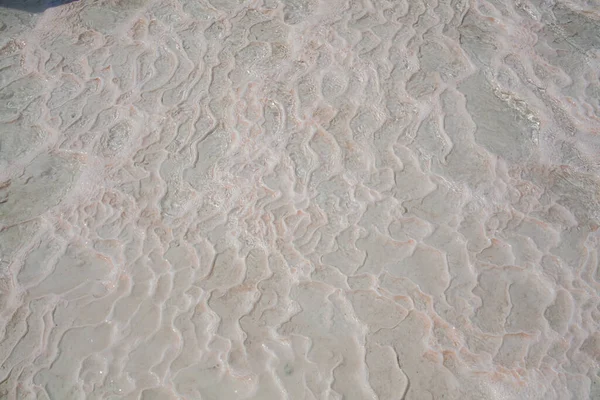 トルコのパムッカレカルシウムトラバーチンの水と石灰岩の床 非対称パターンのクローズアップ 白い波状の質感 ホワイトカルシウム石の質感 石灰岩だ 専用画像 — ストック写真