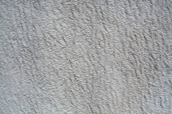 Background of natural white wall Pamukkale calcium travertine in Turkey, asymmetric pattern close-up. White cotton castle texture. Calcium stone textured. Limestone