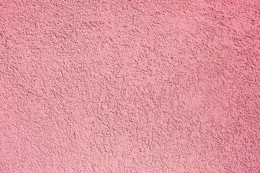 Pembe beton duvarın arka planı. Dekoratif kabartmalı beton ve yapıştırıcı sıva. Pembe alçılı duvar. Alçı desenli arka plan. Bulanık fotoğraf.