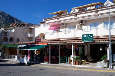 Resimli köy caddesindeki hediyelik eşya ve tekstil dükkanları. Türk kentinde turistik cadde. Turunc, Türkiye - 13 Eylül 2022.