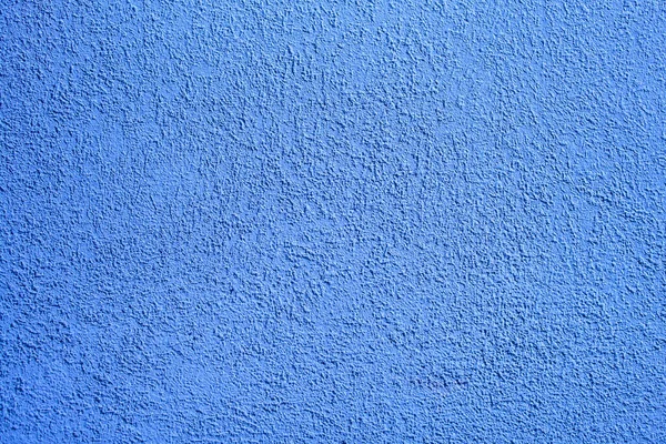 Background of blue concrete wall. Decorative embossed concrete and glue plaster. Blue plastered wall. Plaster textured background. Blurred photo.