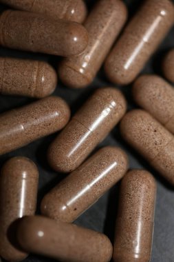 Kahverengi vitamin tozu dolu şeffaf kapsüller. Arka planda yüksek kalite büyük baskı.