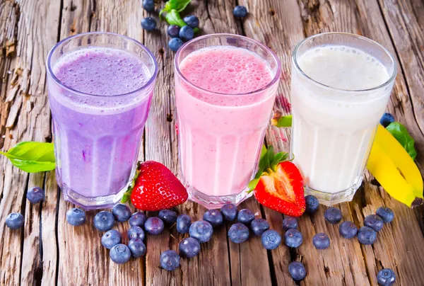 Frutas frescas batido de leite em madeira — Fotografia de Stock