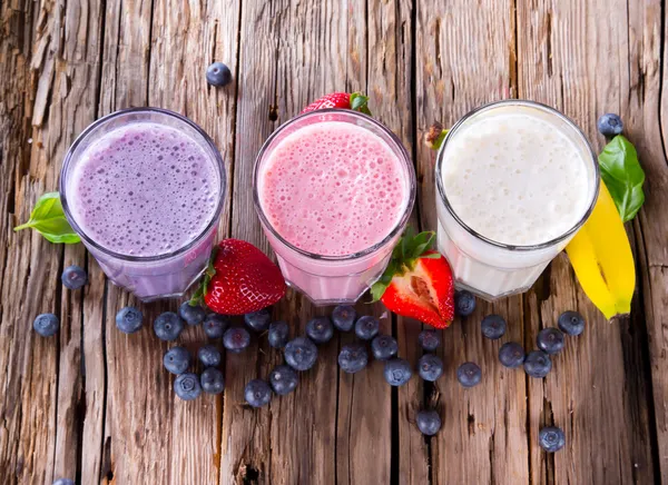 Frutas frescas batido de leite em madeira — Fotografia de Stock