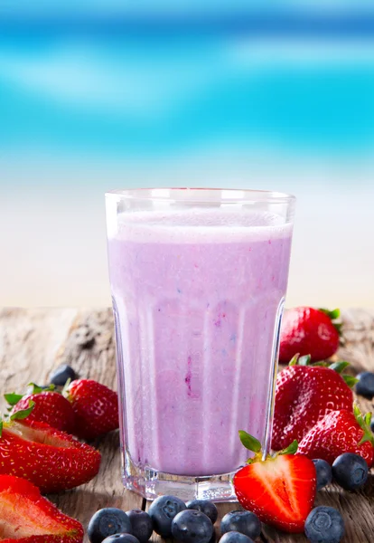 Leite de frutas frescas em madeira — Fotografia de Stock