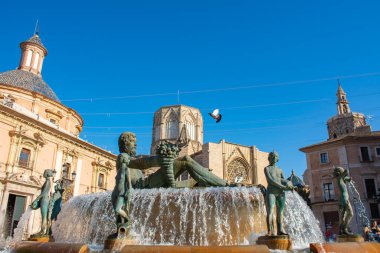 Valencia, İspanya. 7 Temmuz 2021 - Çeşmeli meydan, Bakire Bazilikası, sekizgen kubbeli katedral ve çatıların arkasındaki çan kulesi