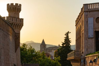 Palma, Balearic Islands, Spain. July 17, 2022 - Sunset from the Palacio March, next to the cathedral. On the left tower of the Royal Palace. In the background bell tower and church of the Holy Cross