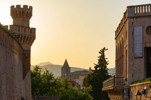 Palma, Balearic Islands, Spain. July 17, 2022 - Sunset from the Palacio March, next to the cathedral. On the left tower of the Royal Palace. In the background bell tower and church of the Holy Cross