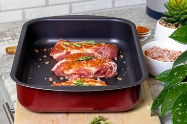 Fırın arkası için metal fırın tepsisinde tuzlu ve baharatlı çiğ biftek dilimleri. Akşam yemeği için taze et hazırlıyorum..