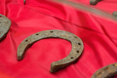 Eski ortaçağ paslı metal nalı müzede kırmızı arka planda..