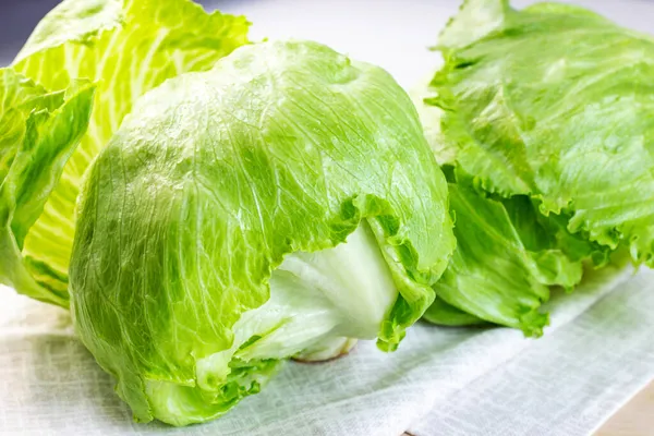 新鮮な緑の氷山レタスサラダはキッチンのテーブルの上に軽い背景に残します — ストック写真