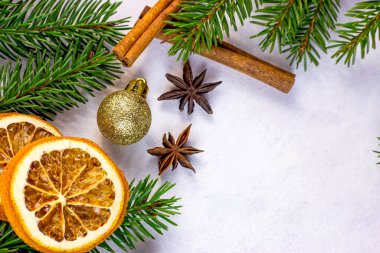 Noel ağacının yeşil köknar dalları, altın takılar, portakallar ve baharatlar Noel çelenkleri çerçevesi olarak beyaz arka planda tebrik kartları için. Kopya alanı ile geleneksel kış tatili şablonu.