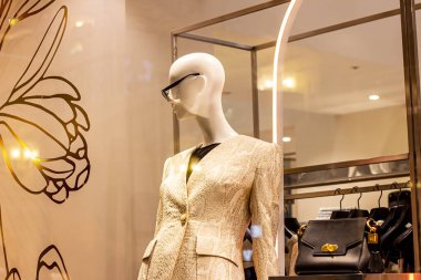 Moda kıyafetleri içinde şık kadın mankenler alışveriş merkezinin perakende mağazasının vitrininde.