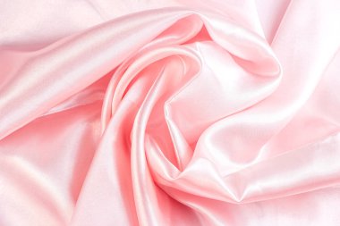Yumuşak desenli arka plan olarak açık renkli pembe renkli ipek dalgalı tekstil deseni. Gül renkli yumuşak saten kumaş örtüsü.