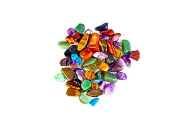 Beyaz arka planda izole edilmiş farklı rengarenk yarı değerli taş yığınlarının üst görünümü.