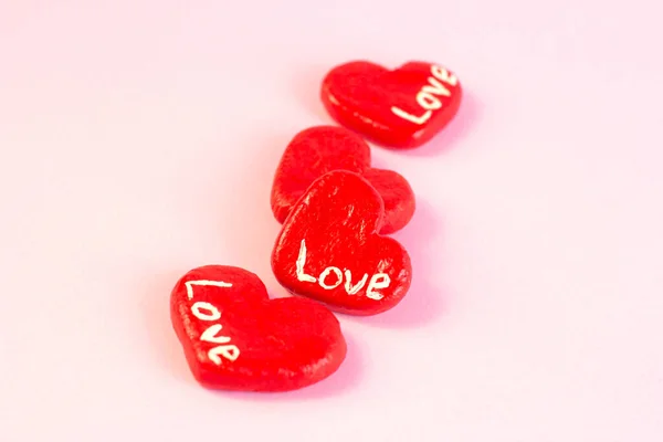 淡いパステルピンクの背景に愛の言葉で明るい赤のハート型の装飾 バレンタインデーのお祝いロマンチックな気持ちのコンセプト — ストック写真
