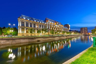 Bükreş, Roma. Geceleri Dambovita nehri yakınlarındaki Adalet Sarayı. Yansımalı gece fotoğrafı. Palatul Justiei.