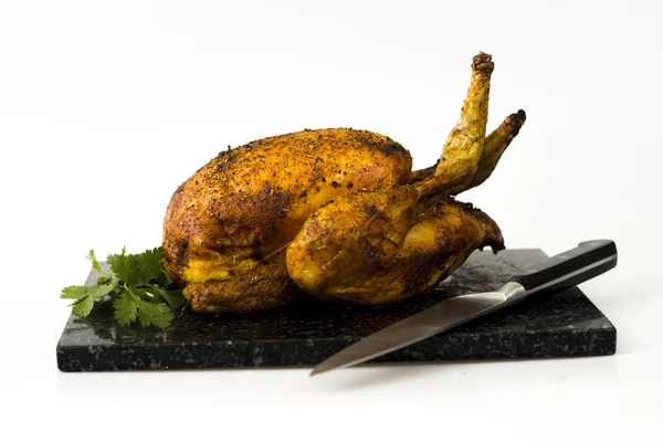 Roast chicken and coriander on chopping board — Stock Photo, Image