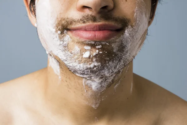 Queixo do jovem coberto de espuma de barbear — Fotografia de Stock