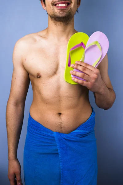 Happy man with flip-flops going to the beach