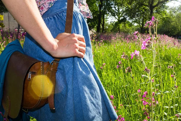 Junge Frau mit Vintage-Tasche steht auf Feld — Stockfoto