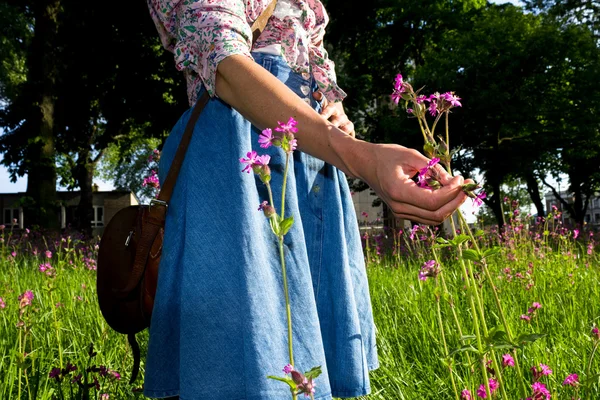 Mujer joven recogiendo flores —  Fotos de Stock