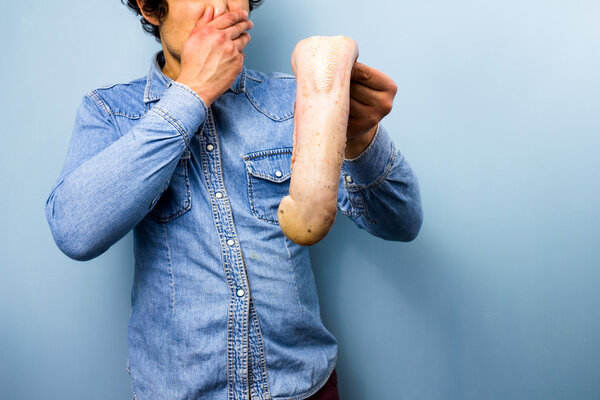 Disgusted man holding a raw ox tongue