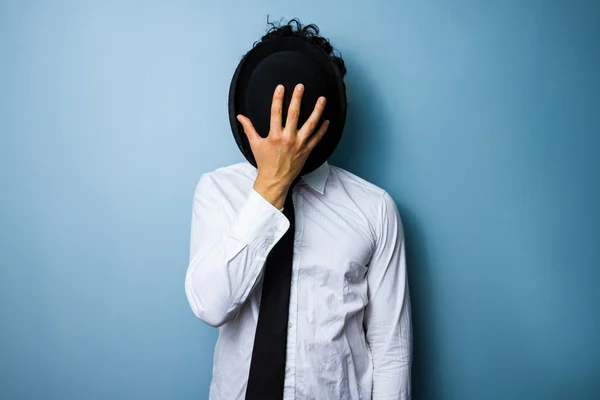 Businessman hiding his face behind a bowler hat — Stock Photo, Image