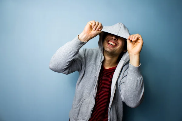 Šťastný člověk směje zpod jeho hoodie — Stock fotografie
