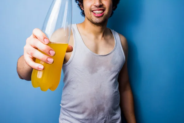 Joven bebiendo bebida energética después de un entrenamiento sudoroso —  Fotos de Stock