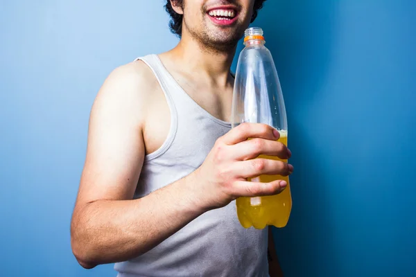 Joven bebiendo bebida energética después de un entrenamiento sudoroso — Foto de Stock