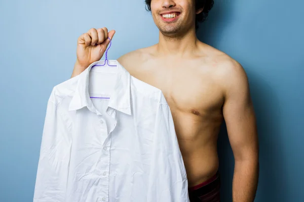 Jovem homem multirracial segurando sua camisa branca limpa — Fotografia de Stock