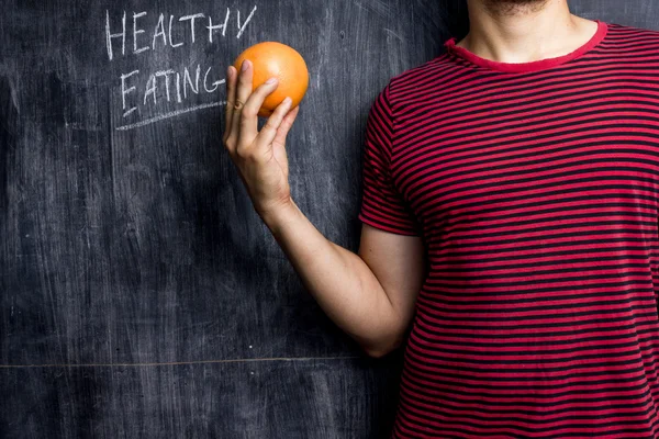 Uomo che promuove una sana alimentazione davanti alla lavagna — Foto Stock