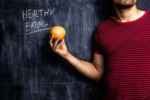 Άνθρωπος που προωθούν την υγιεινή διατροφή, μπροστά από το μαυροπίνακα — Φωτογραφία Αρχείου