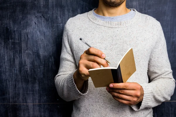 Homem tomando notas por quadro negro — Fotografia de Stock