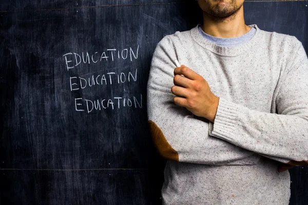 Teacher standing by blackboard — Zdjęcie stockowe