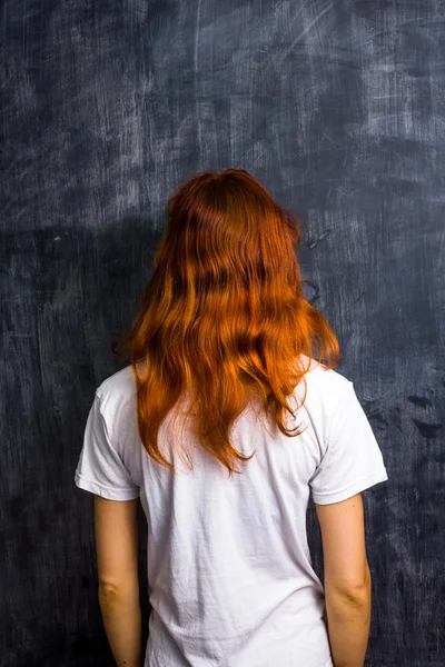 Redhead woman by blank blackboard — Stock Photo, Image