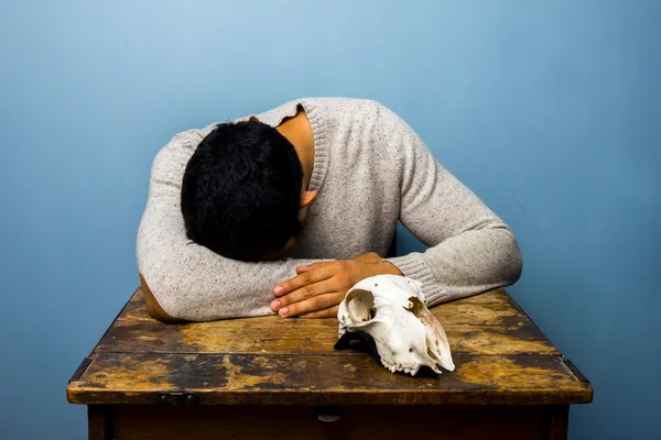 Trauriger Mann mit Totenkopf am Schreibtisch — Stockfoto