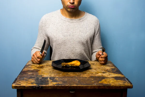 Junger Mann mit Hühnchen-Drumstick zum Essen — Stockfoto