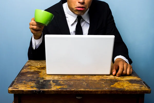 L'uomo d'affari è sorpreso e quasi versa il caffè sul notebook — Foto Stock