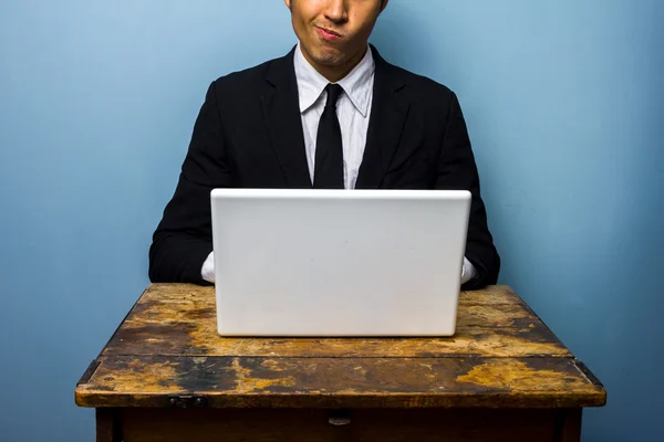 Empresário confuso trabalhando no laptop — Fotografia de Stock